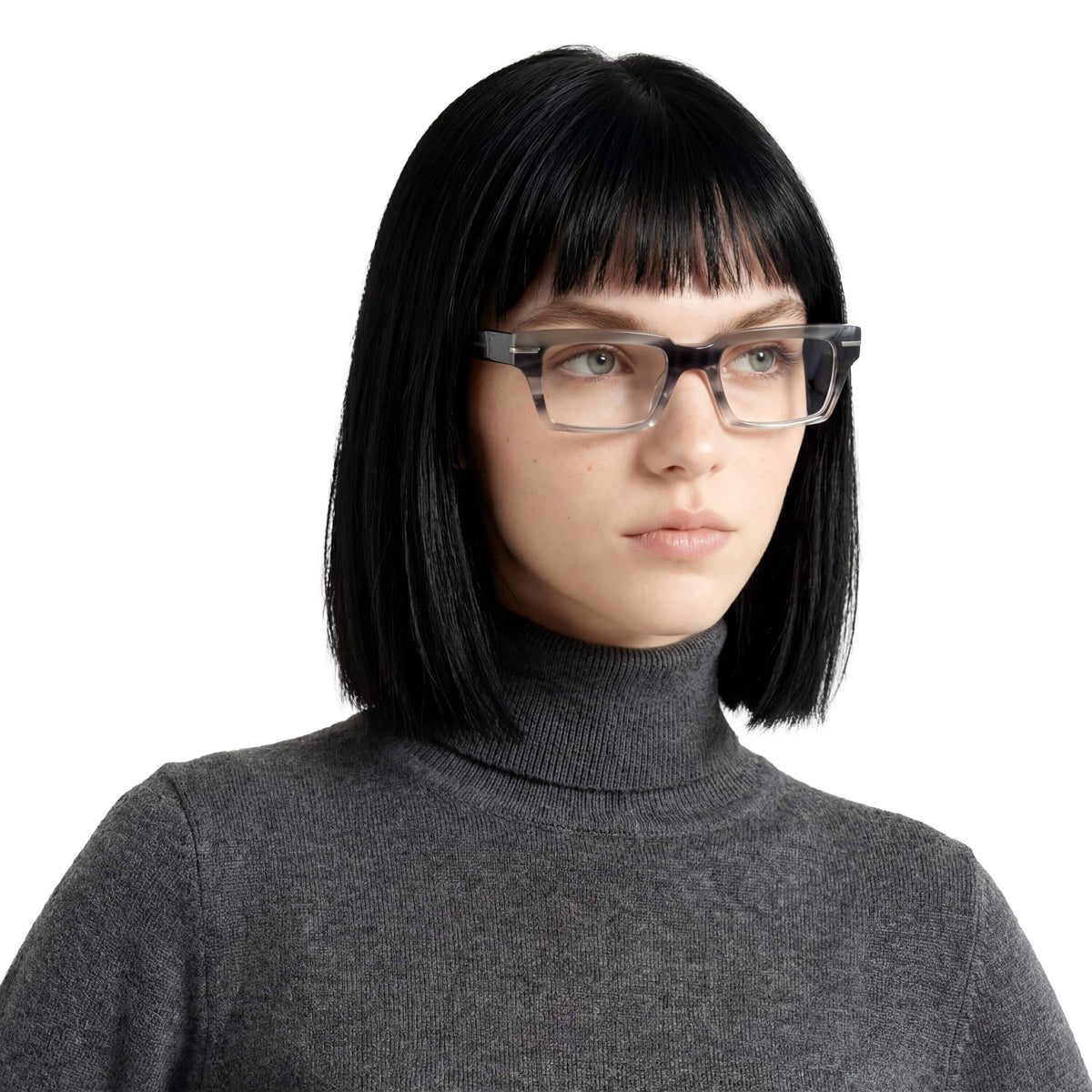 Person wearing glasses and a gray turtleneck on a white background