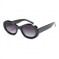 Oval sunglasses with a glossy black acetate frame and gradient gray lenses, shown from a three-quarters angle on a white background.