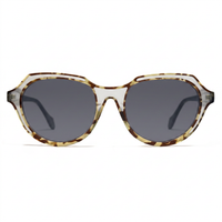 Oversized sunglasses with a translucent tortoiseshell frame in brown and beige tones, paired with dark gray lenses, shown against a plain white background.