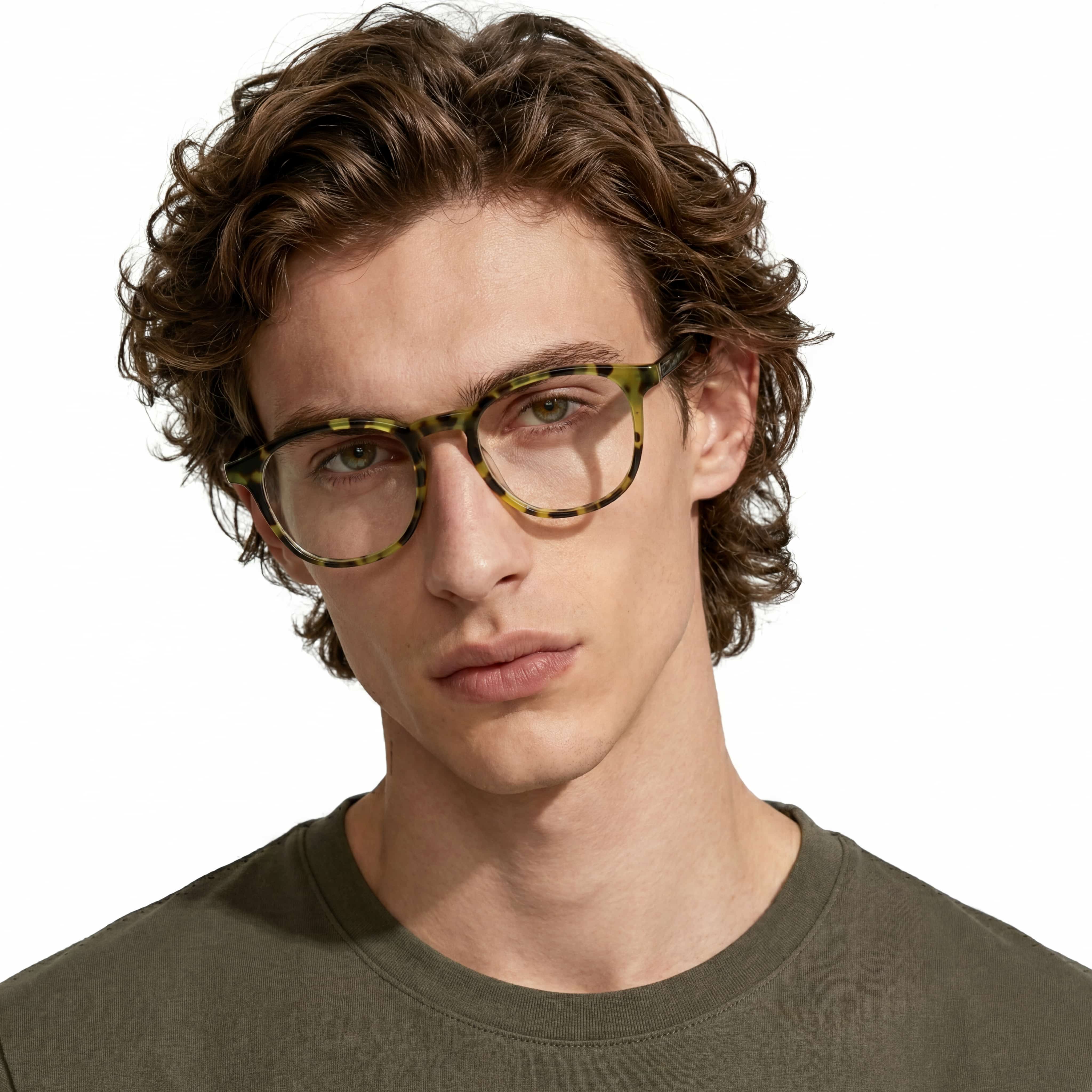 Man wearing tortoiseshell glasses with a neutral background