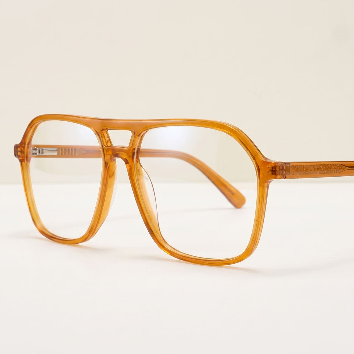 Featuring a classic geometric silhouette in orange acetate, finished with...