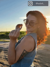 Red-haired woman wearing tortoise cat-eye sunglasses at sunset countryside, lifestyle product shot