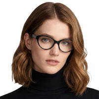 Woman wearing black glasses and a black turtleneck on a white background