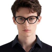 Person wearing black glasses and a dark shirt on a white background