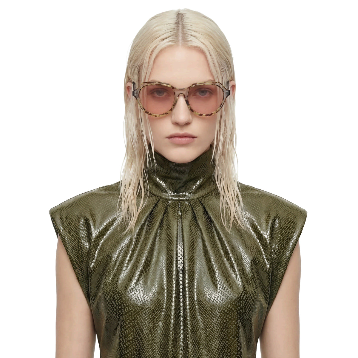 Person wearing a green metallic top and sunglasses on a white background