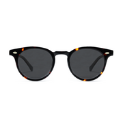 Round sunglasses with a glossy black acetate frame, subtle tortoiseshell patterns at the corners, and dark gray lenses.