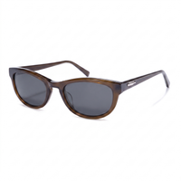 A pair of classic cat-eye sunglasses with a translucent brown acetate frame and dark gray lenses, shown on a clean white background.