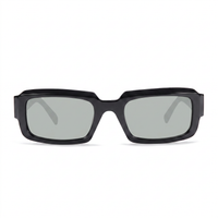 A pair of chunky, oversized square sunglasses with a glossy black frame and light gray lenses, shown from a front-facing perspective on a clean white background.