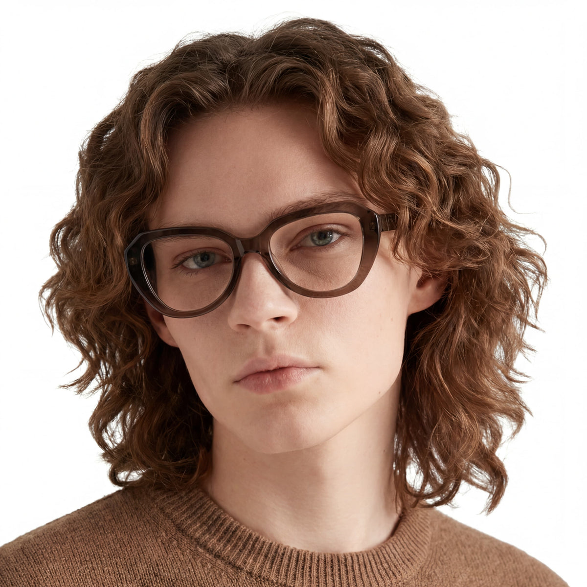 Person wearing glasses and a brown sweater on a white background