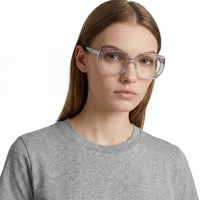 Person wearing clear eyeglasses and a gray shirt on a white background