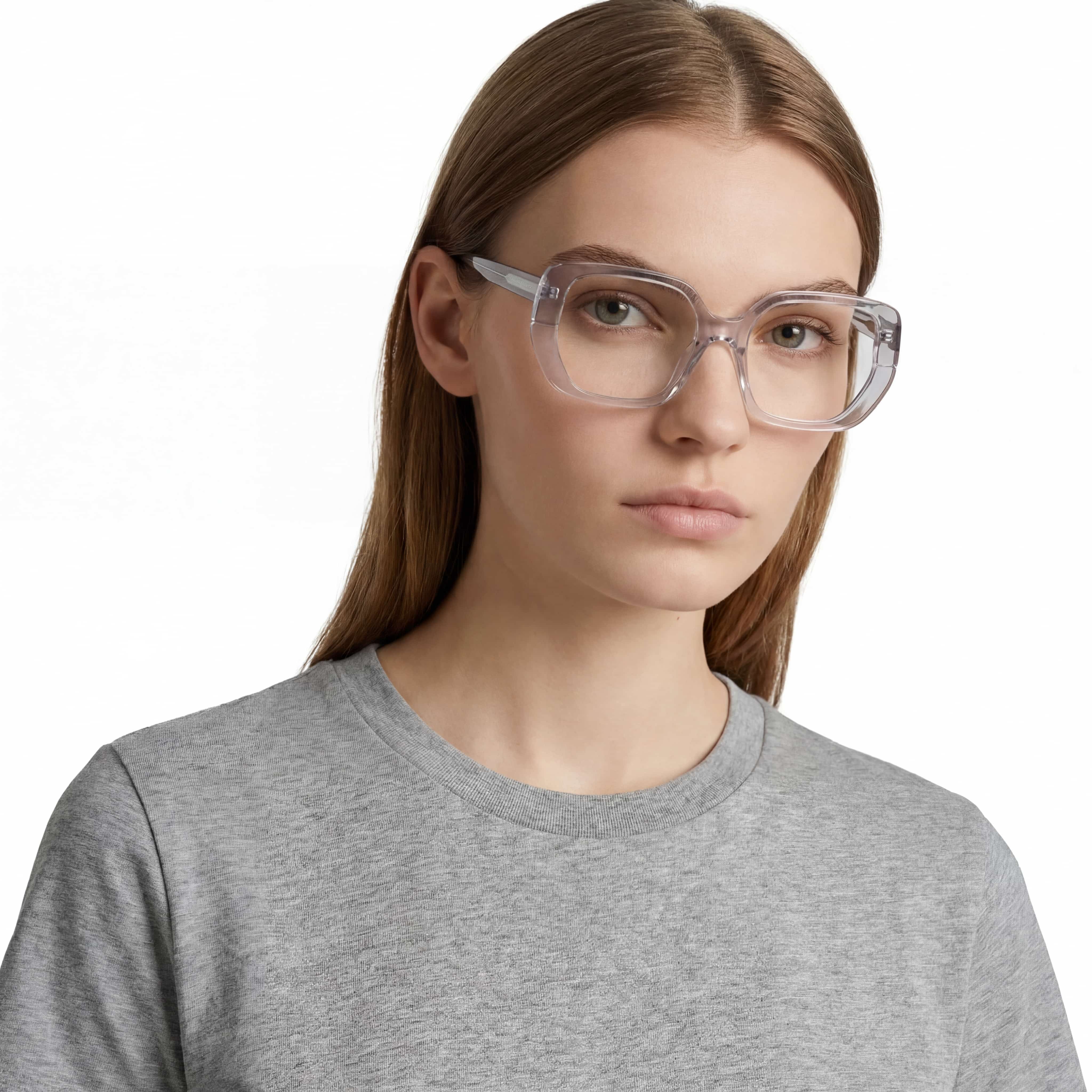 Person wearing clear eyeglasses and a gray shirt on a white background