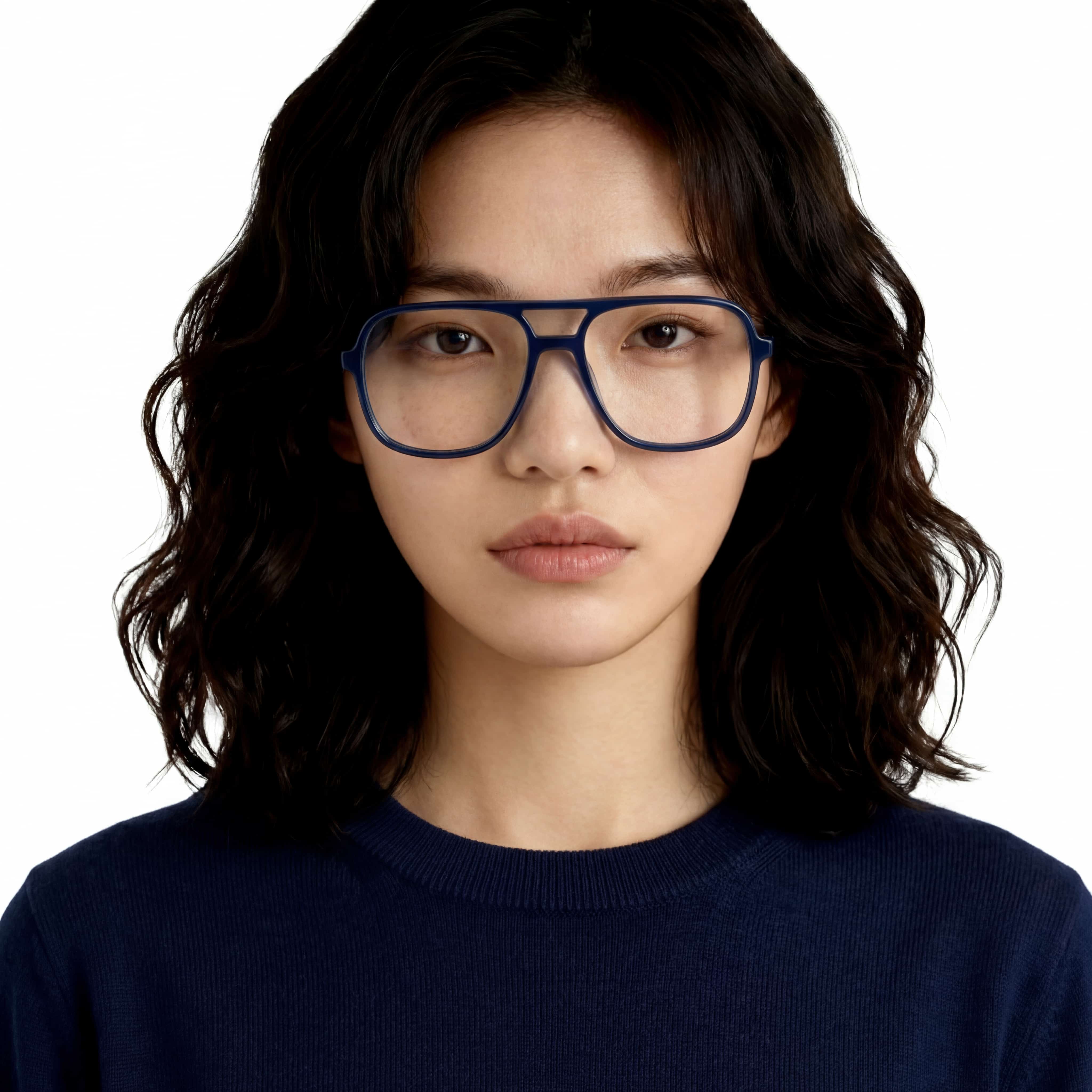 Person wearing blue eyeglasses and a navy sweater on a white background
