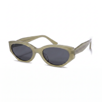 Oversized cat-eye sunglasses with a translucent olive green acetate frame and dark gray lenses, shown on a plain white background.