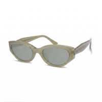 Oversized cat-eye sunglasses with a translucent olive green acetate frame and matching tinted lenses, shown on a plain white background.