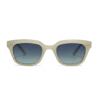 A pair of square sunglasses with a translucent light beige acetate frame and blue gradient lenses, shown against a plain white background.