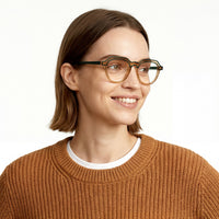Woman wearing glasses and a brown sweater on a white background