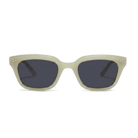 A pair of square sunglasses with a thick, matte light beige frame and dark gray lenses, shown against a plain white background.