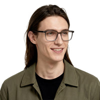 Man wearing glasses and a green jacket on a white background
