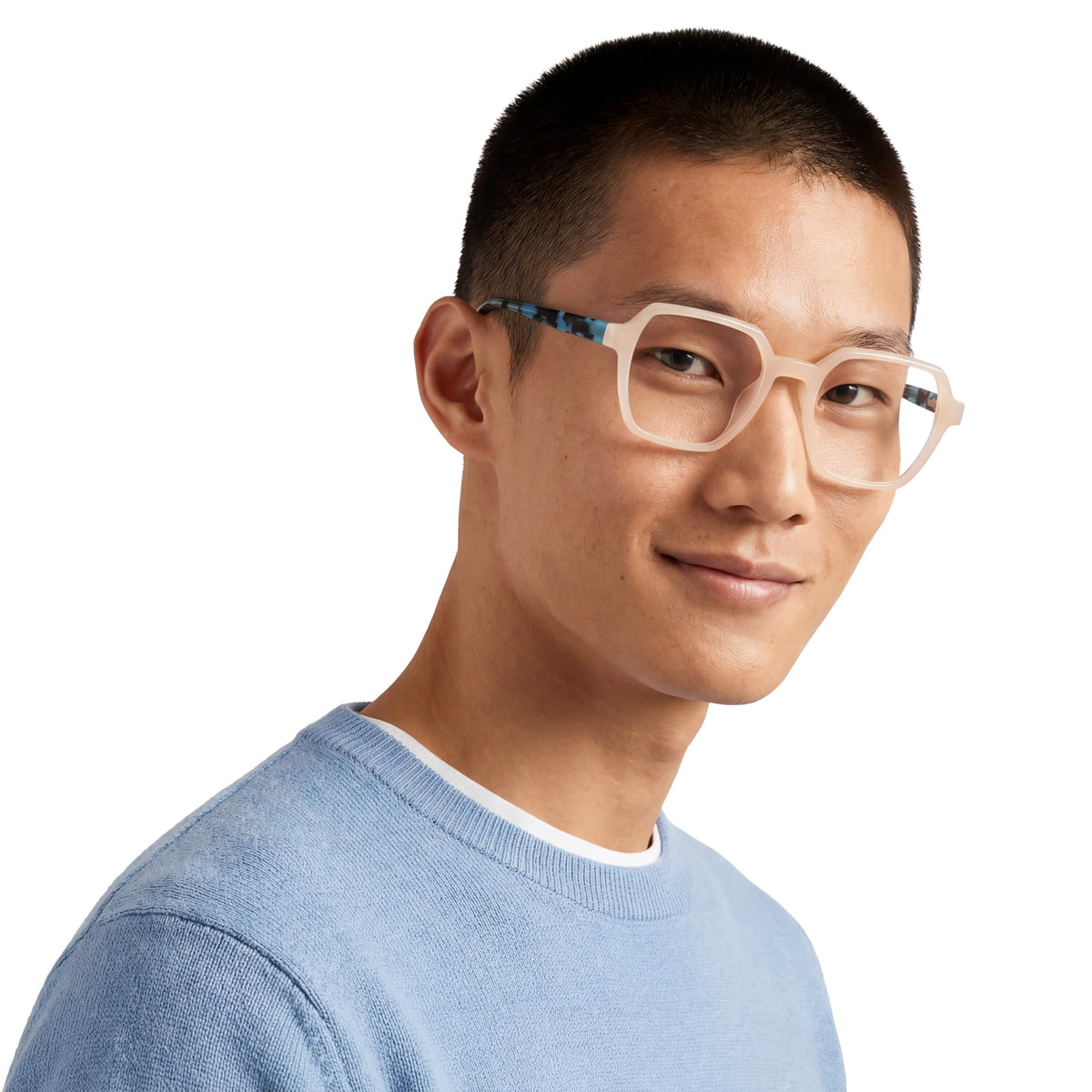 Man wearing glasses and a light blue sweater on a white background
