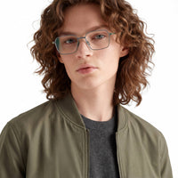 Person wearing glasses and a green jacket on a white background