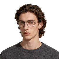 Man wearing glasses and a dark gray sweater on a white background