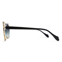 Side profile of a pair of sunglasses with a black acetate temple arm, a gold tortoiseshell frame, and light blue mirrored lenses, shown on a white background.