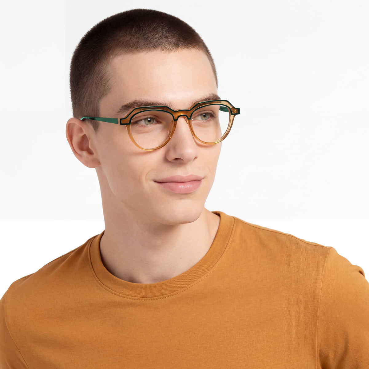 Person wearing glasses and a mustard yellow shirt on a white background