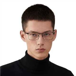 Person wearing glasses and a black turtleneck against a white background