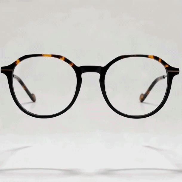 Dark tortoise marbled round acetate eyeglasses frame, light gray studio background, front shot